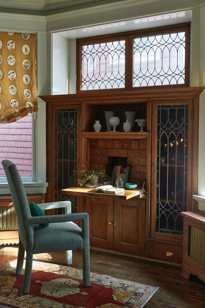 A cozy office nook with an exquisite built-in and charming leaded glass windows within an 1890 Queen Anne Victorian home in Chicago.