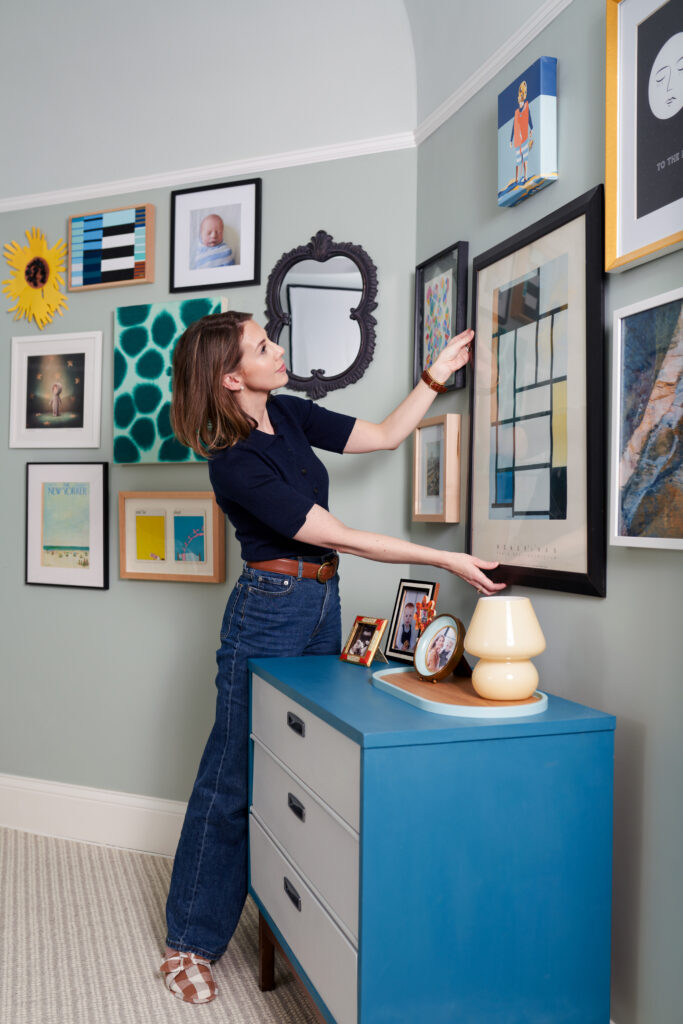 Meghan Jay of Meghan Jay Design, an interior design studio in Chicago, straightening a mix of artwork collected from her travels.